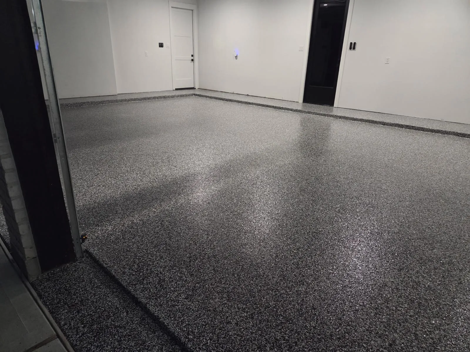 Black and white full broadcast flake floor in a finished Houston garage